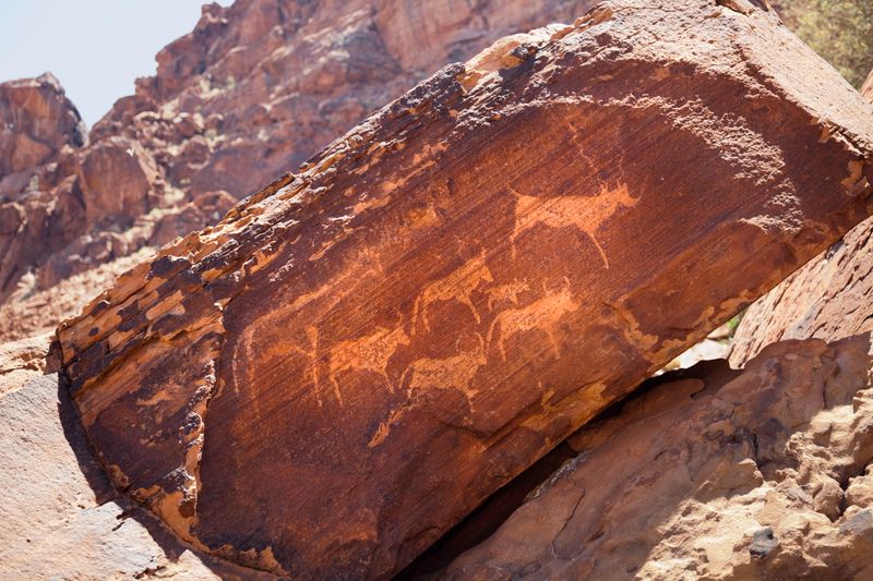 Damaraland’s Twyfelfontein rock engravings showcase ancient Bushmen petroglyphs etched into Namibia’s desert sandstone.