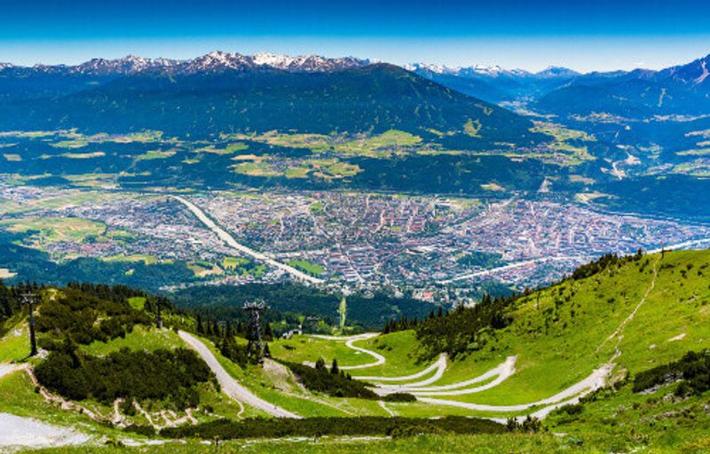 View from above of Innsbruck city in Austria with the alps mountain range, taken from the Nordkettenbahnen cable car.