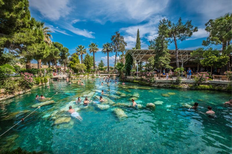 Tourists swimming in the Ancient pool of Cleopatra.