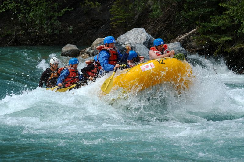 Adventurous tourists on a white water rafting tour in the Kicking Horse River.