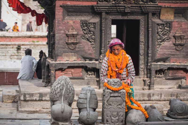 A local woman leaves flowers at the Pashupatinath Temple.