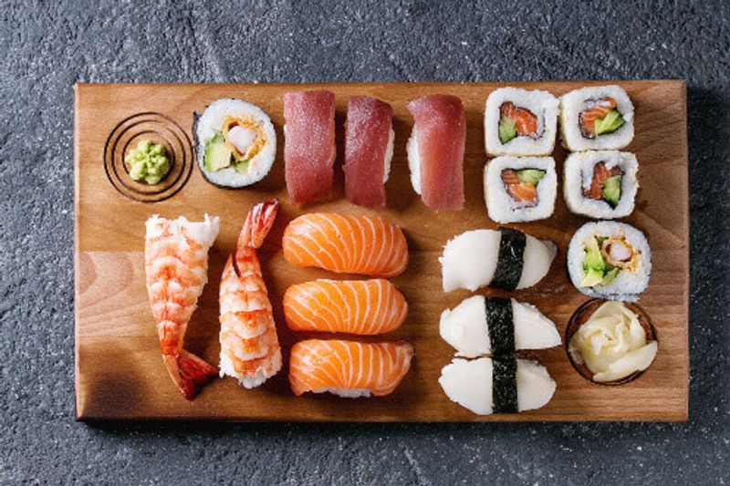 A traditional sushi set including Nigiri and Sushi Rolls on a wooden serving board.