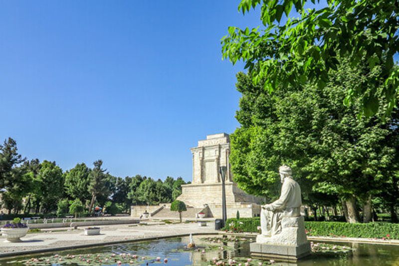 Photo 1: Tomb of Ferdowsi with his statue on the pond in Tus, Iran.