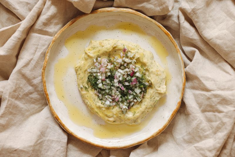 Traditional Santorini fava topped with onions and olive oil, served as a meze dish in a local taverna