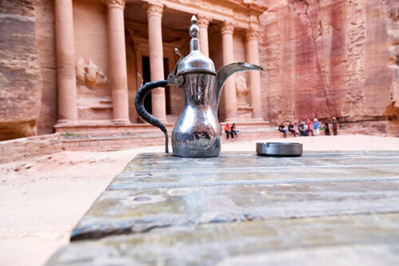 A traditional coffee sits on a table outside tourist attractions in Petra.