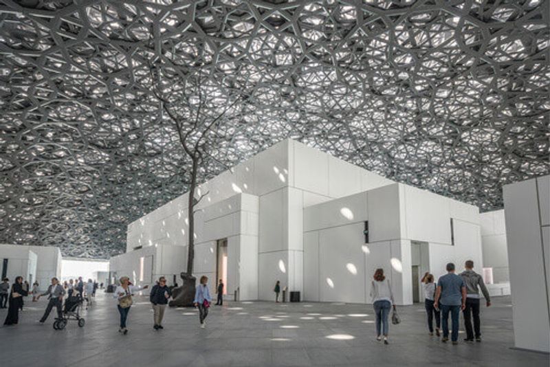 Interior of the Louvre Museum showing reflections of the “Rain of Light” dome.