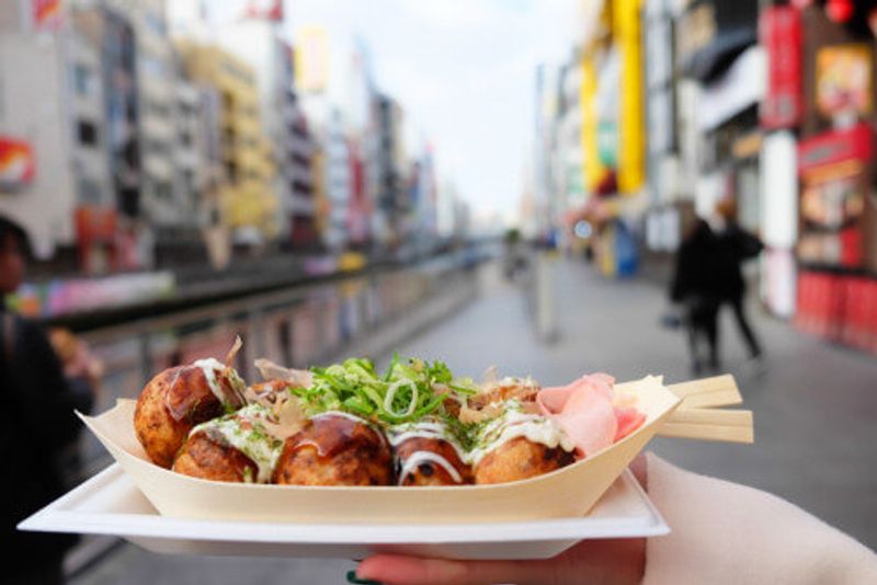 The delicious local delicacy of Takoyaki is displayed in front of Dotonbori, Osaka.