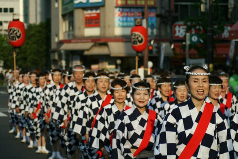 Japanese locals dressed in traditional outfits in a parade.