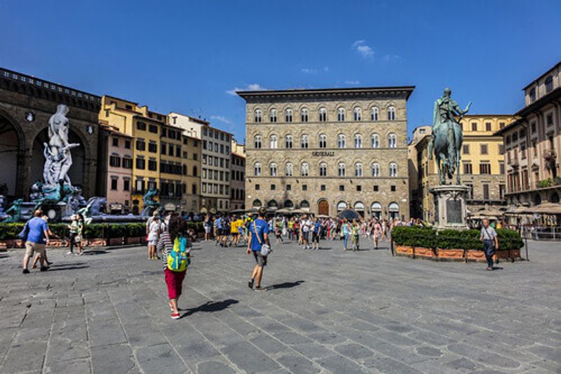 Tourists admire Italian architecture and sights of the Piazza Della Signoria.