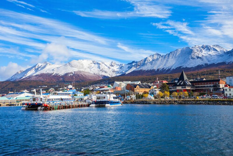 The bustling Ushuaia port where boats come and go against the backdrop of the mountain.