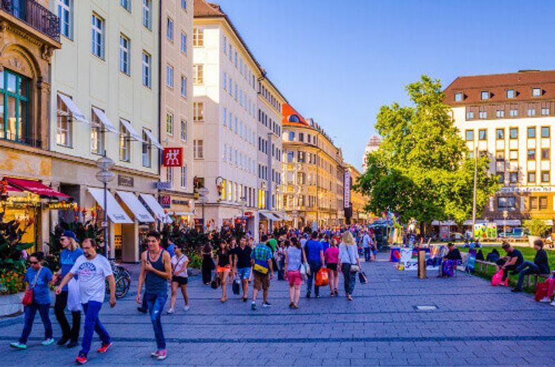 People walking through a shopping street towards Marienhof in Munich.