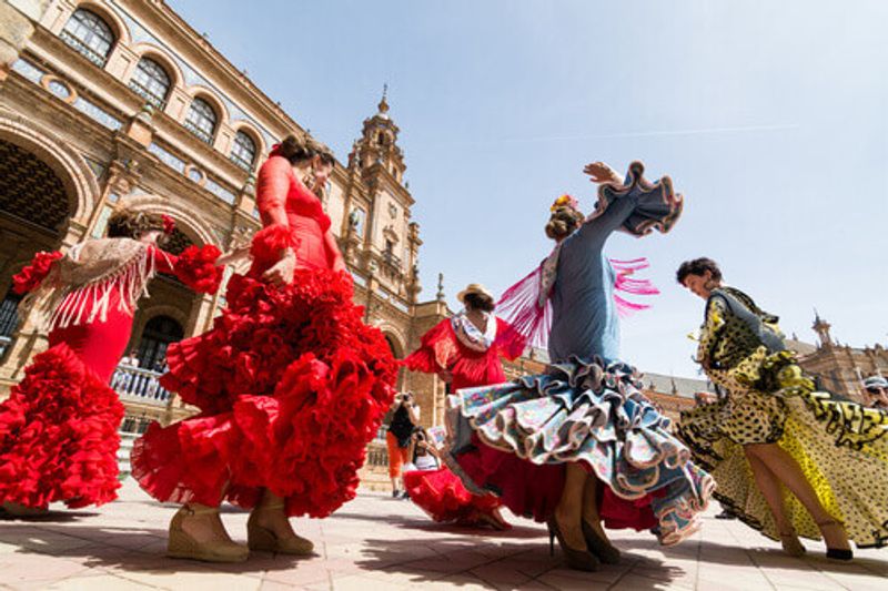 Young women dance flamenco on the Plaza de Espana in Seville, Spain.