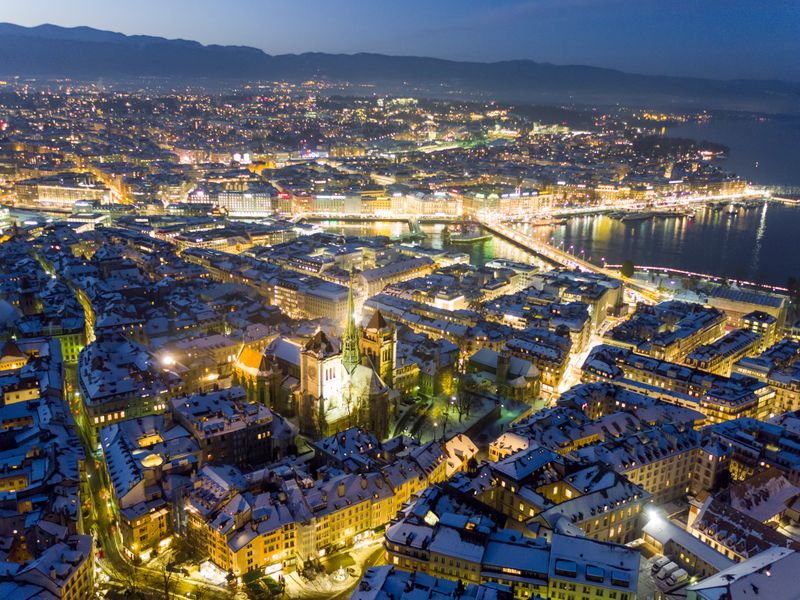 Aerial view of Geneva’s historic old town blanketed in snow beside Lake Geneva