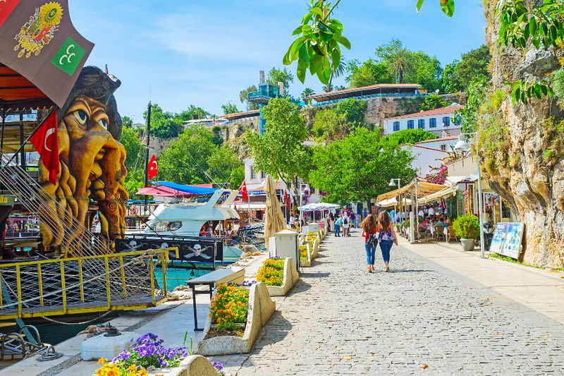 Tourists walking the old port of Kaleici with cafes and themed ships