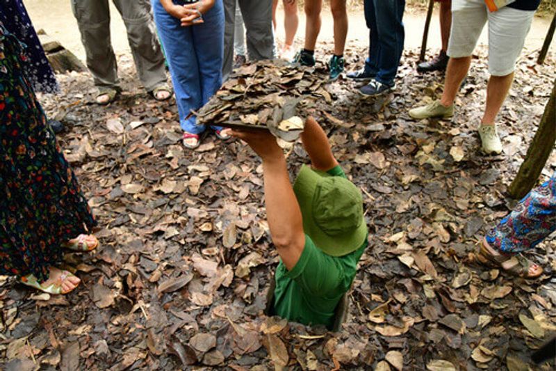 A man demonstrates the size of the The Cu Chi tunnels in Vietnam.