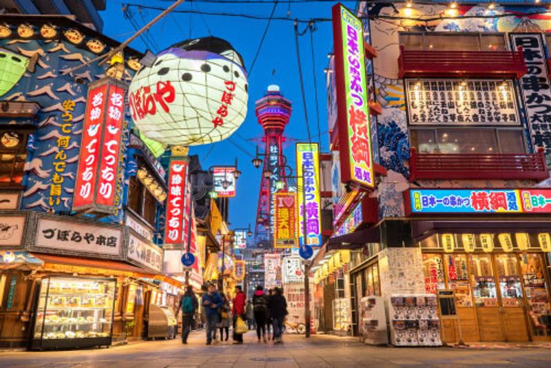 Lanterns and signs visible in Shinsekai at night.