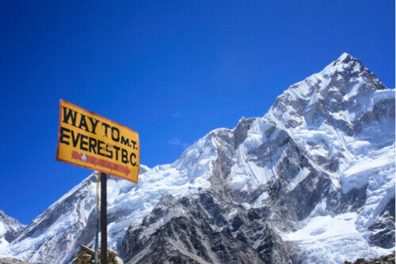 A sign stands at the base of Mount Everest.