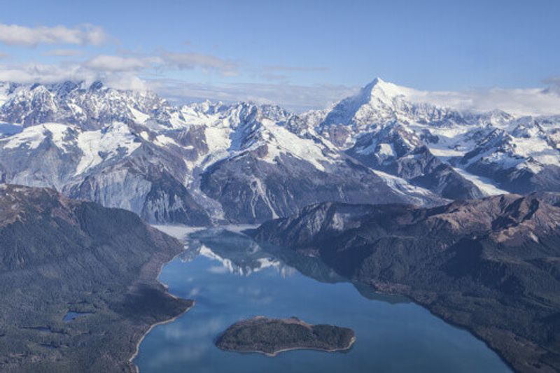 An aerial view of Lituya Bay with the Mt. Fairweather Range in the background on a sunny day.