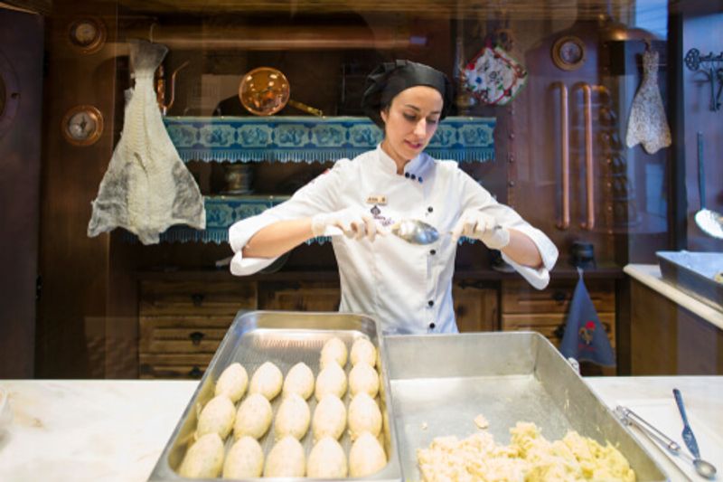 A local female chef is making cod fritters in Portugal.