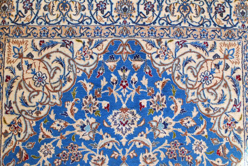 A blue Nain Rug laid out.