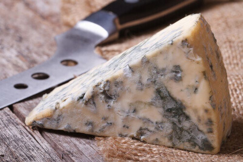 Mouldy blue cheese on a wooden table