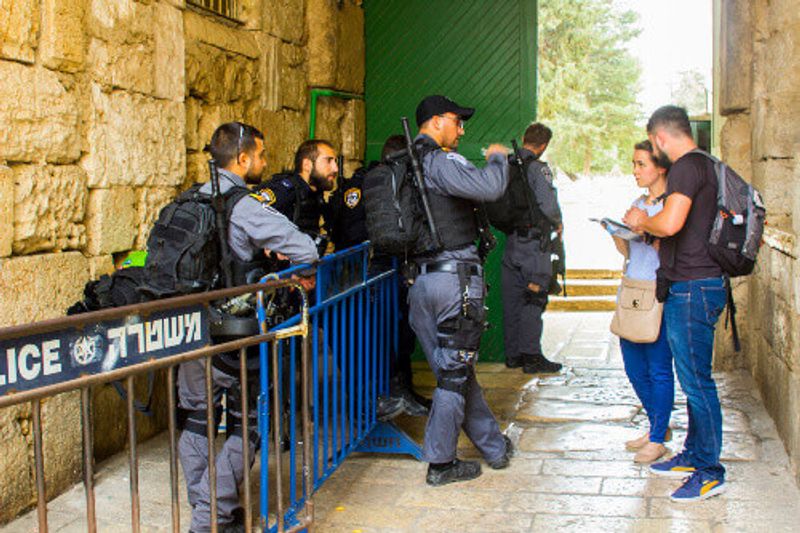 Israeli police talking to tourists of the Dome of the Rock Complex in Jerusalem, Israel.