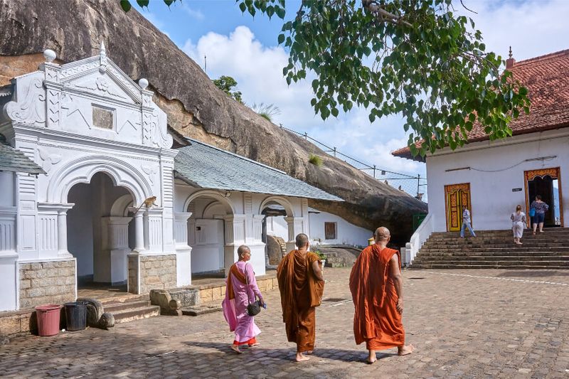 Monks walking on the sacred caves of Dambulla.