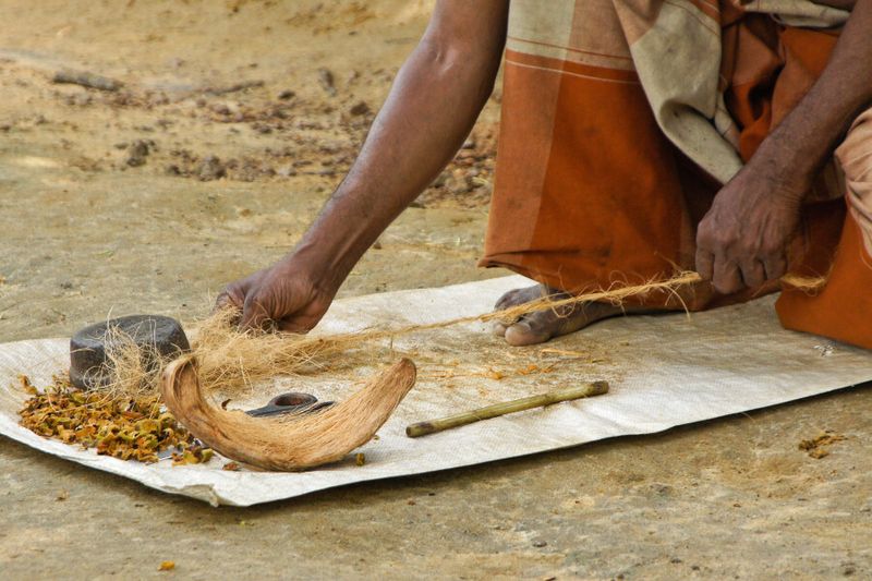 A man twisting coconut husk fibre into a twine