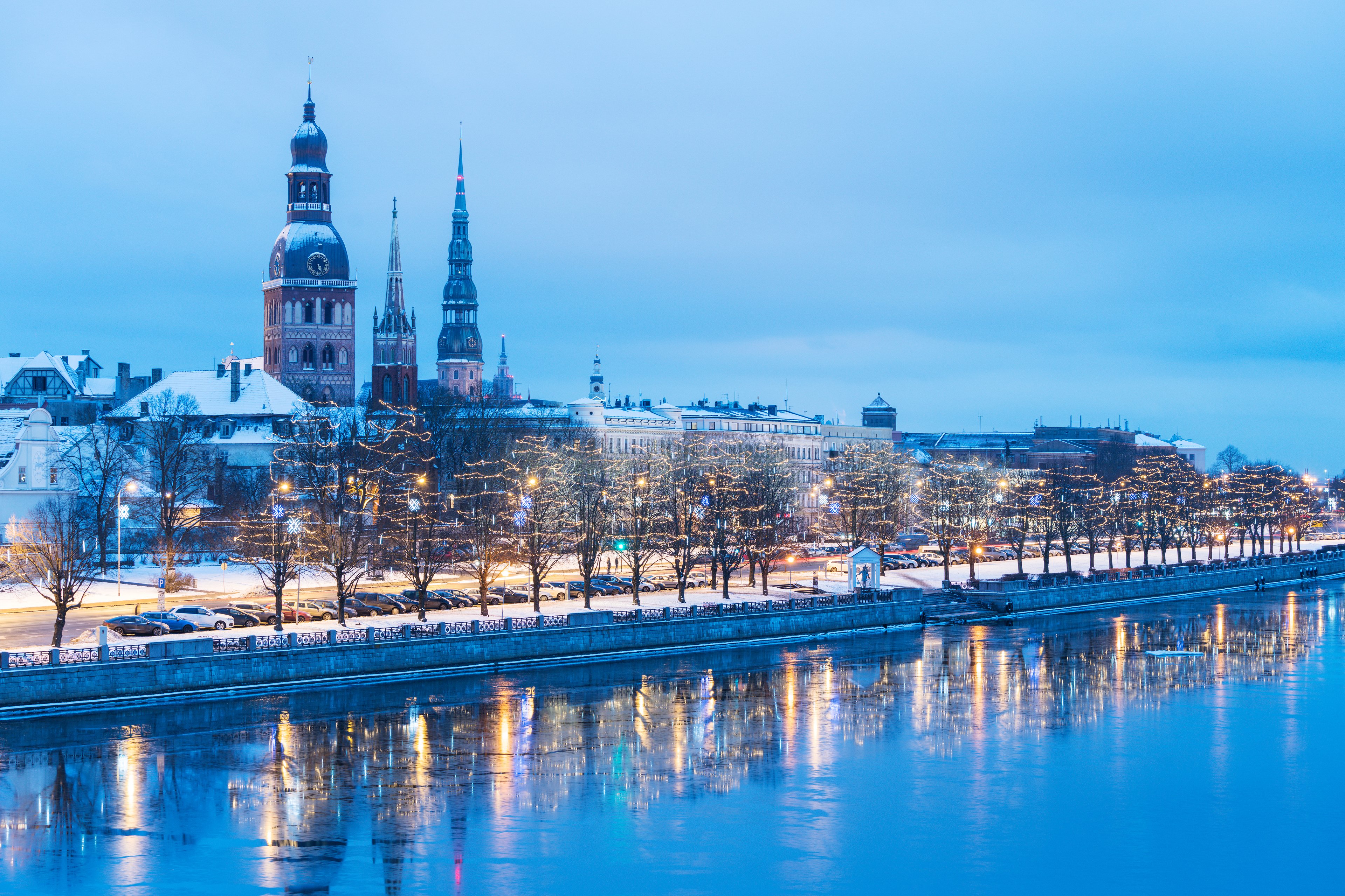 Snow-covered rooftops and church towers in Riga old town during winter, showcasing the Baltic capitals in the cold season.