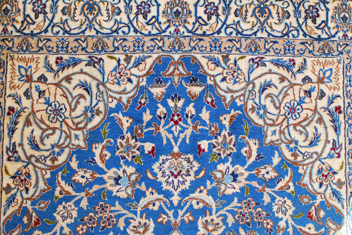 A blue Nain Rug laid out.