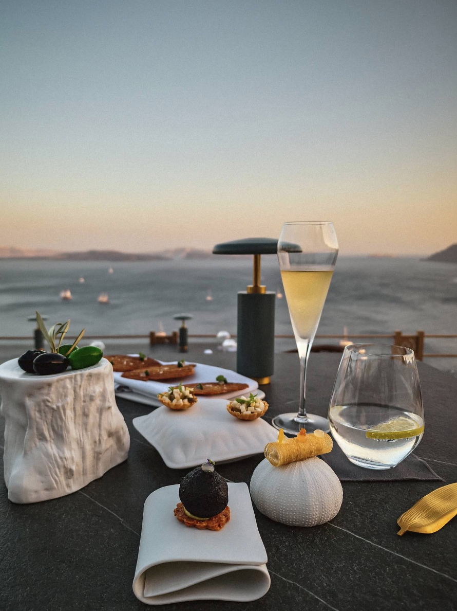Taverna-style Santorini dinner with wine, grilled seafood, and Cycladic views at sunset