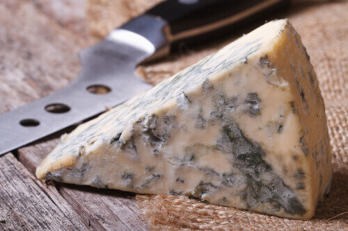 Mouldy blue cheese on a wooden table