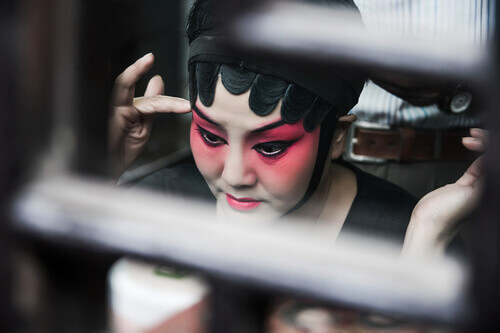 Close-up of a Chinese opera performer doing her make up.