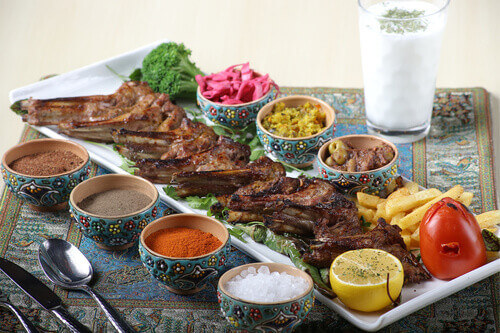 A Shashlik Kebab is plated alongside side dishes and sauces.
